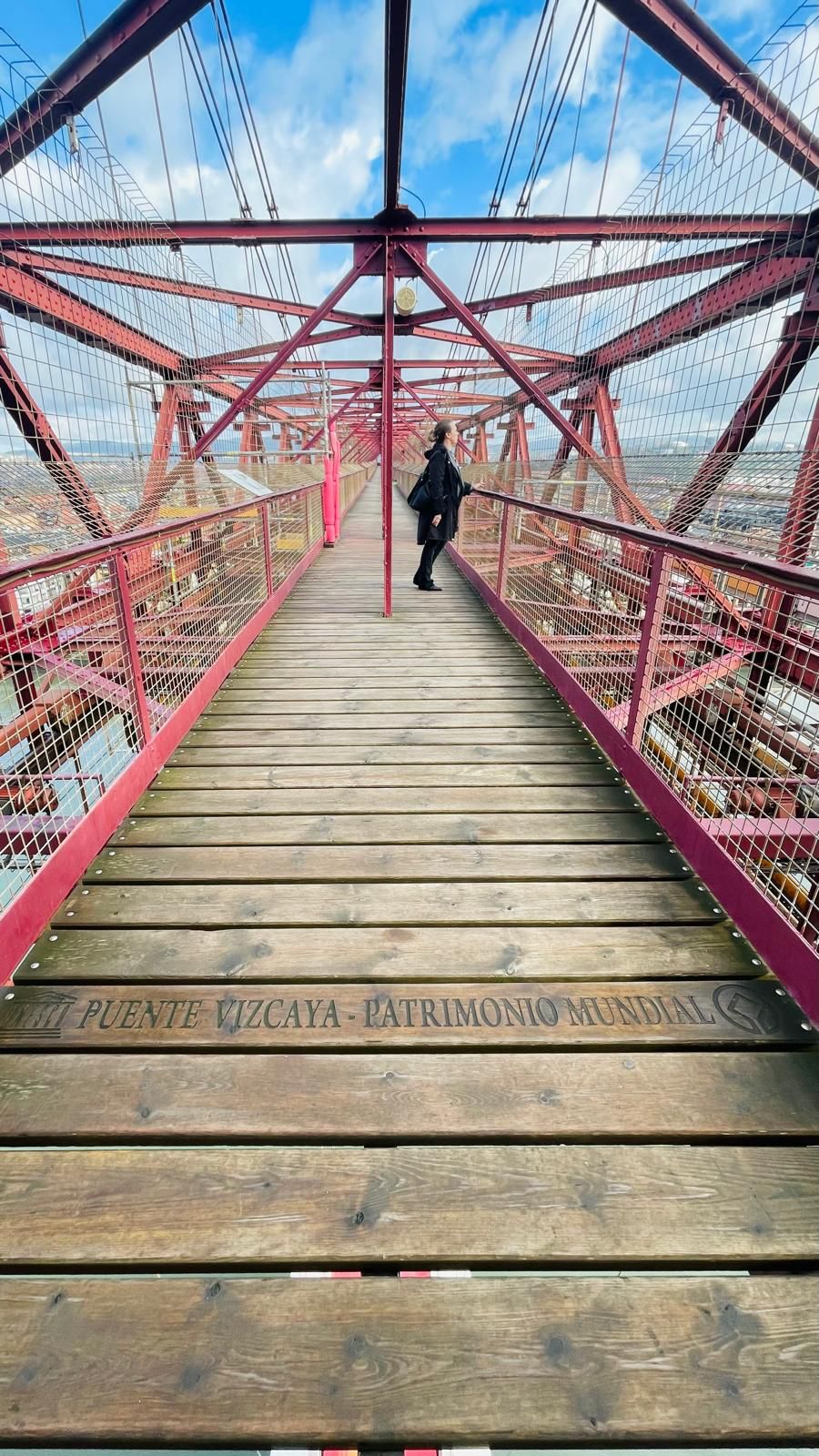 Persona caminando sobre la pasarela del Puente de Vizcaya, estructura de hierro declarada Patrimonio Mundial.