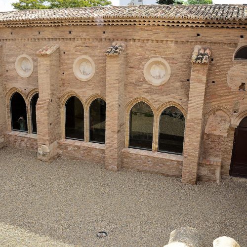 Claustro mudéjar de la ex colegiata de Santa María de Borja con ventanales góticos y muros de ladrillo.